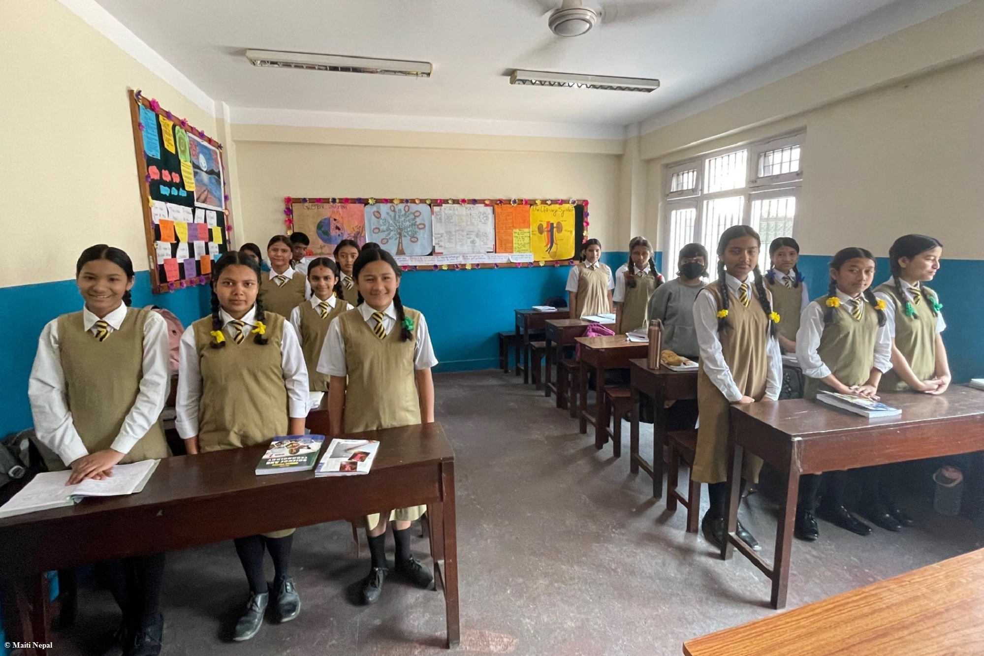 Zwei Männer und ein Kind stehen um einen neugepflanzten Baum herum und betrachten ihn. Landwirtschaft Indien: Aufforstung für den Klimaschutz in Indien.