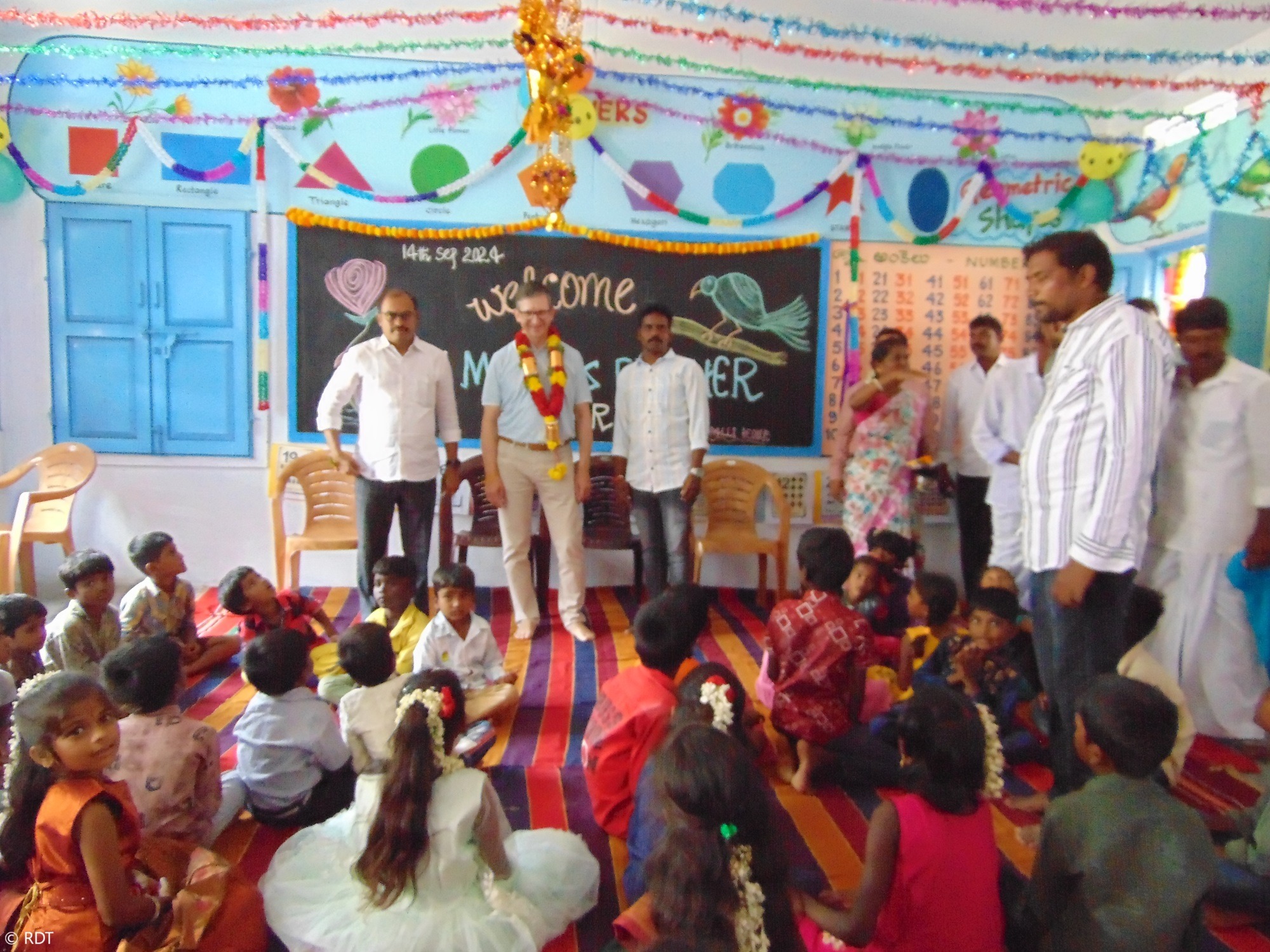 Lehrer und Schulkind an einer Wandtafel in einer Stiftungsschule in Indien. Alphabetisierung in Indien fördern