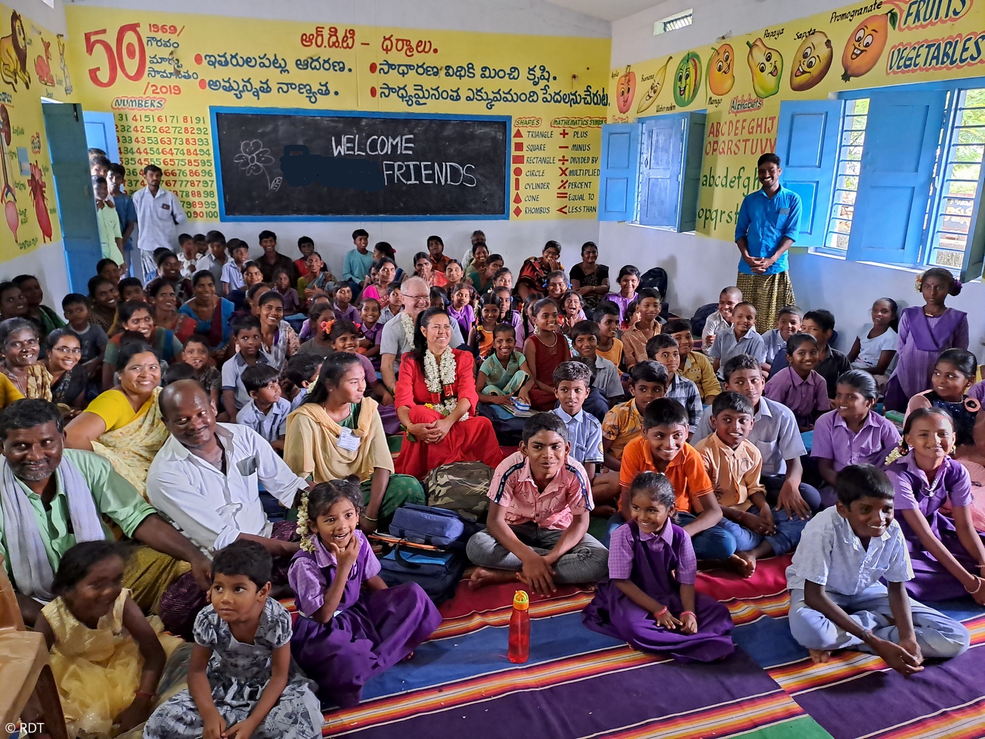 Mädchen schreibt mit Kreide an eine Schultafel in Indien. Mit Stiftungsschulen Alphabetisierung in Indien fördern