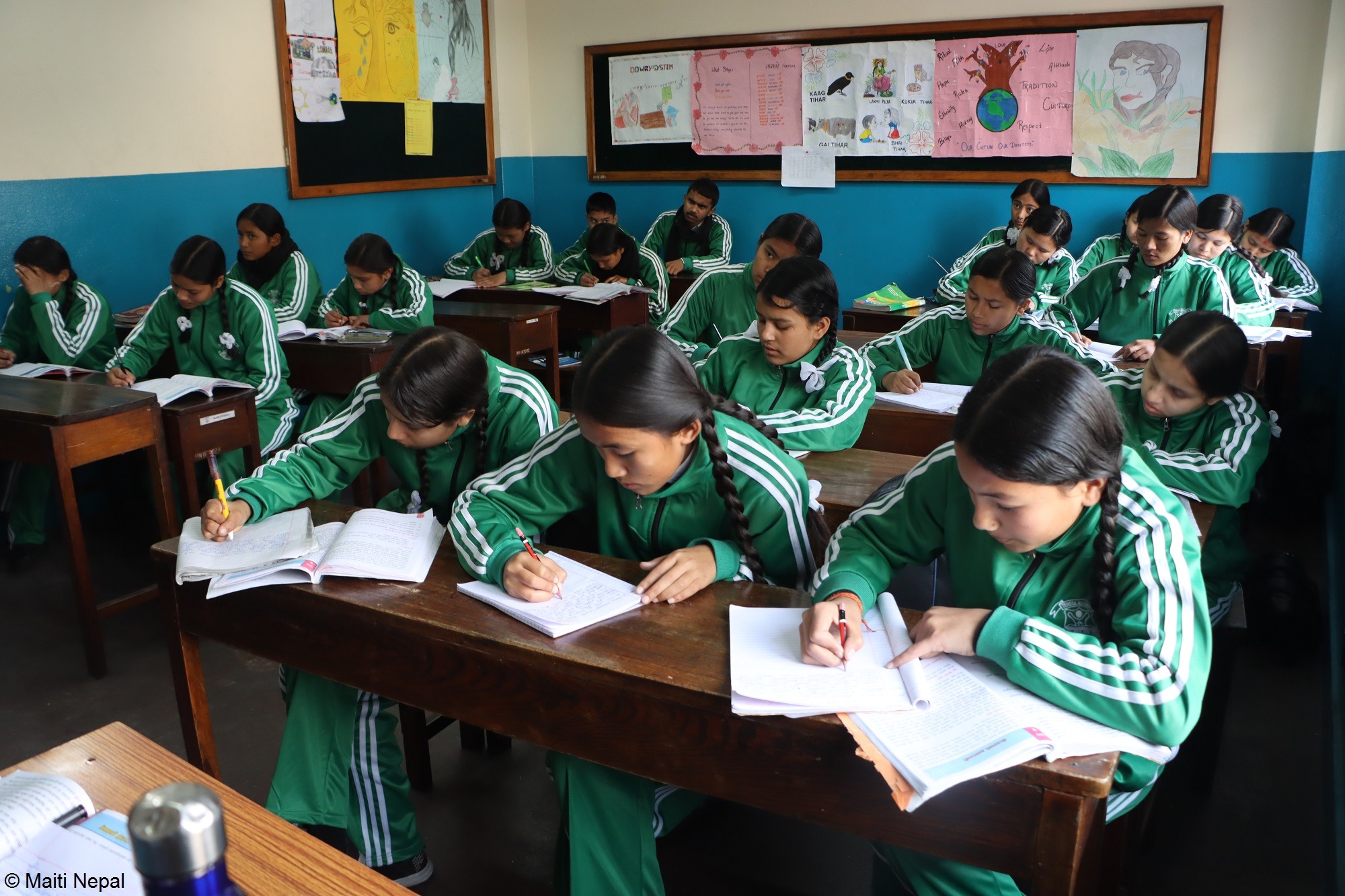 Zwei Männer und ein Kind stehen um einen neugepflanzten Baum herum und betrachten ihn. Landwirtschaft Indien: Aufforstung für den Klimaschutz in Indien.