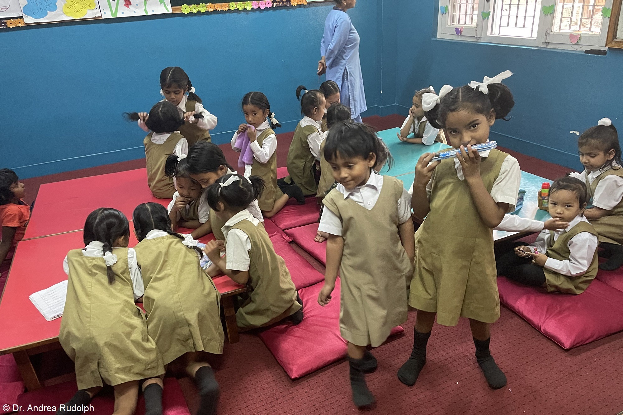 Zwei Männer und ein Kind stehen um einen neugepflanzten Baum herum und betrachten ihn. Landwirtschaft Indien: Aufforstung für den Klimaschutz in Indien.